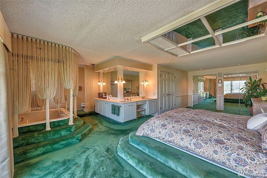 a green carpeted 1970s bedroom with a hot tub in it