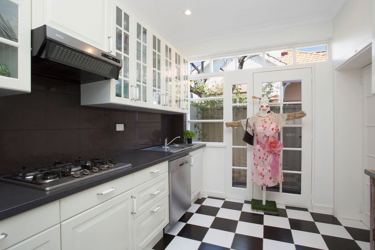 a kitchen with a strange life sized cow in a dress