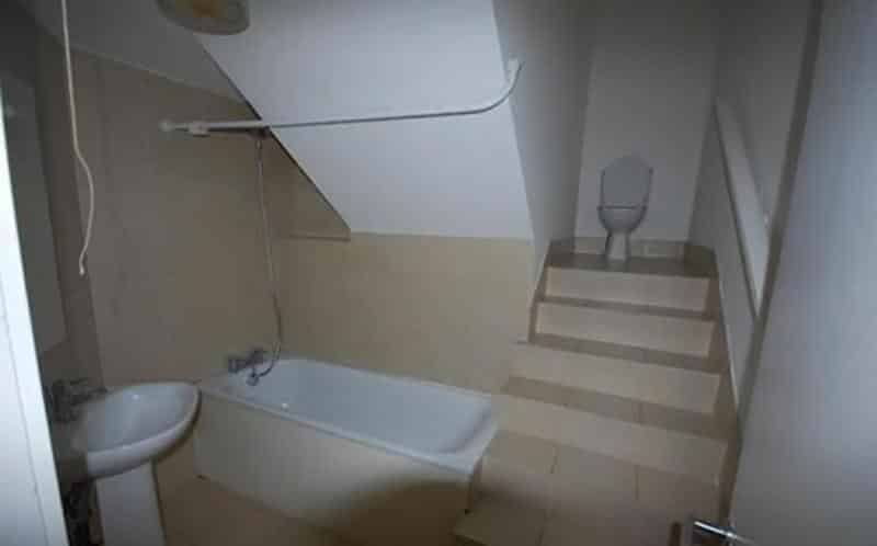 a bathroom with stairs leading to the toilet