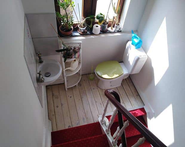 a toilet precariously placed on a stair landing