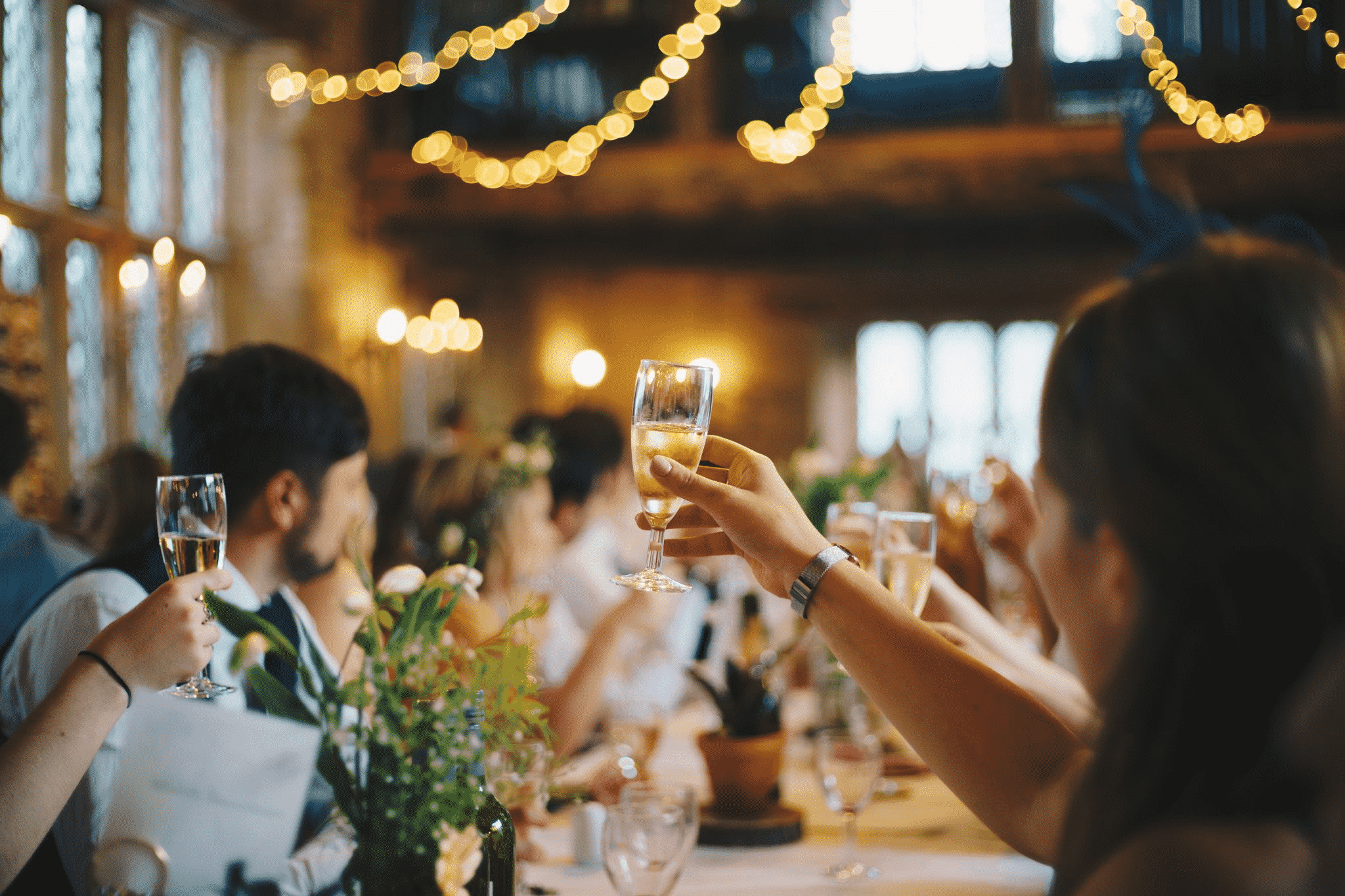 a group of people raise a glass in a toast at a fancy event.