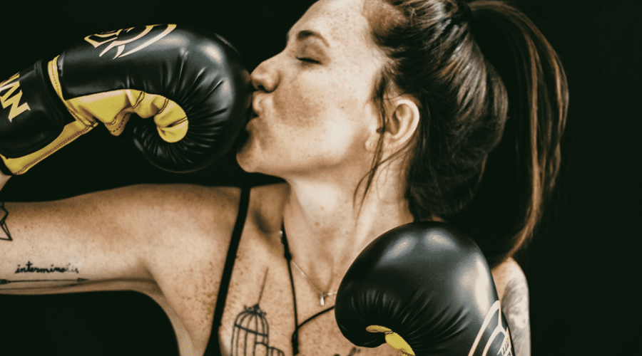 female boxer kissing black gloves