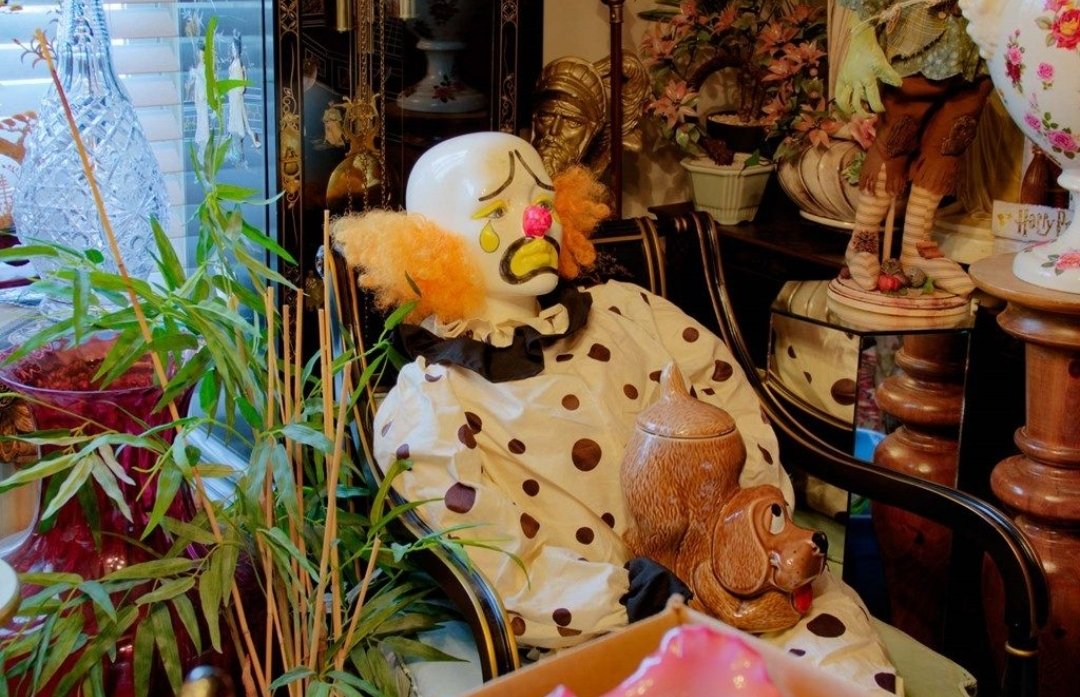 cluttered living room with close up of life sized clown and dog cookie jar