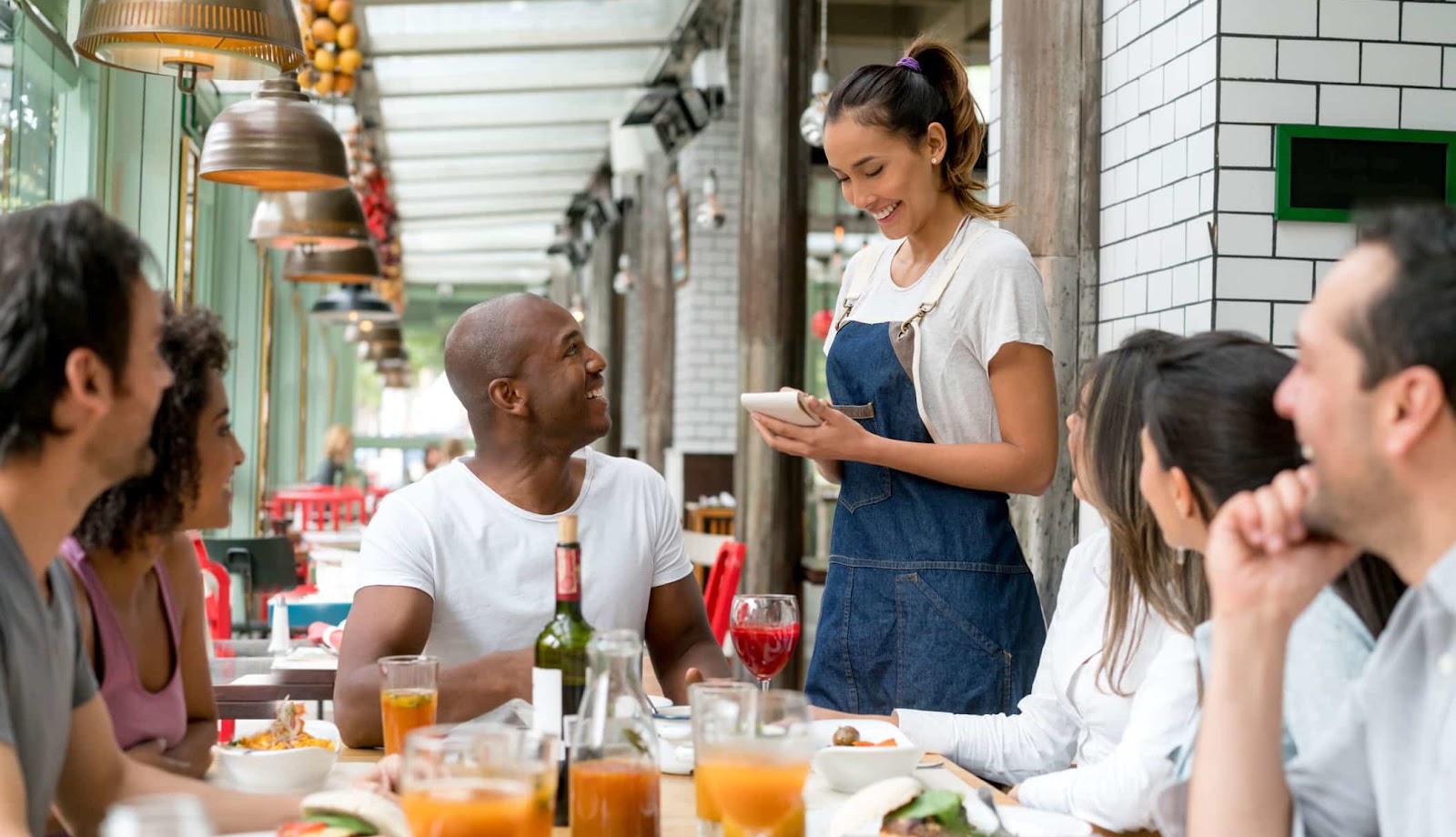 A waitress takes orders at a table with several people in the party