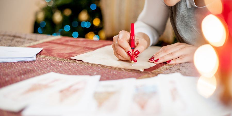 a lady writing on paper using red ballpen