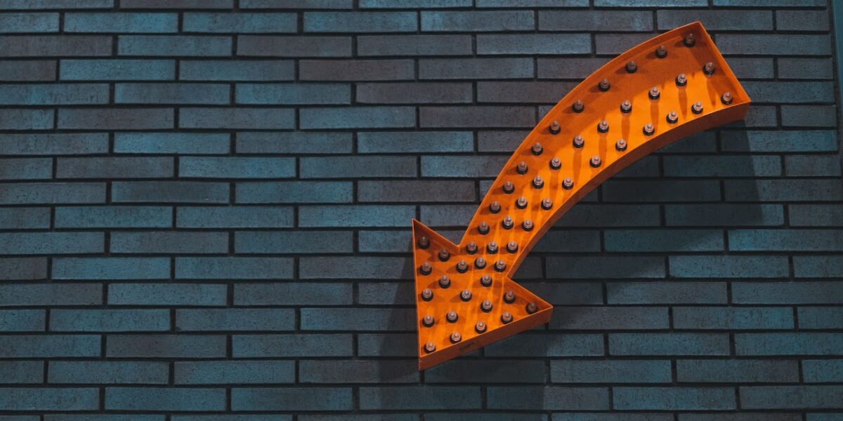 orange arrow signage in wall