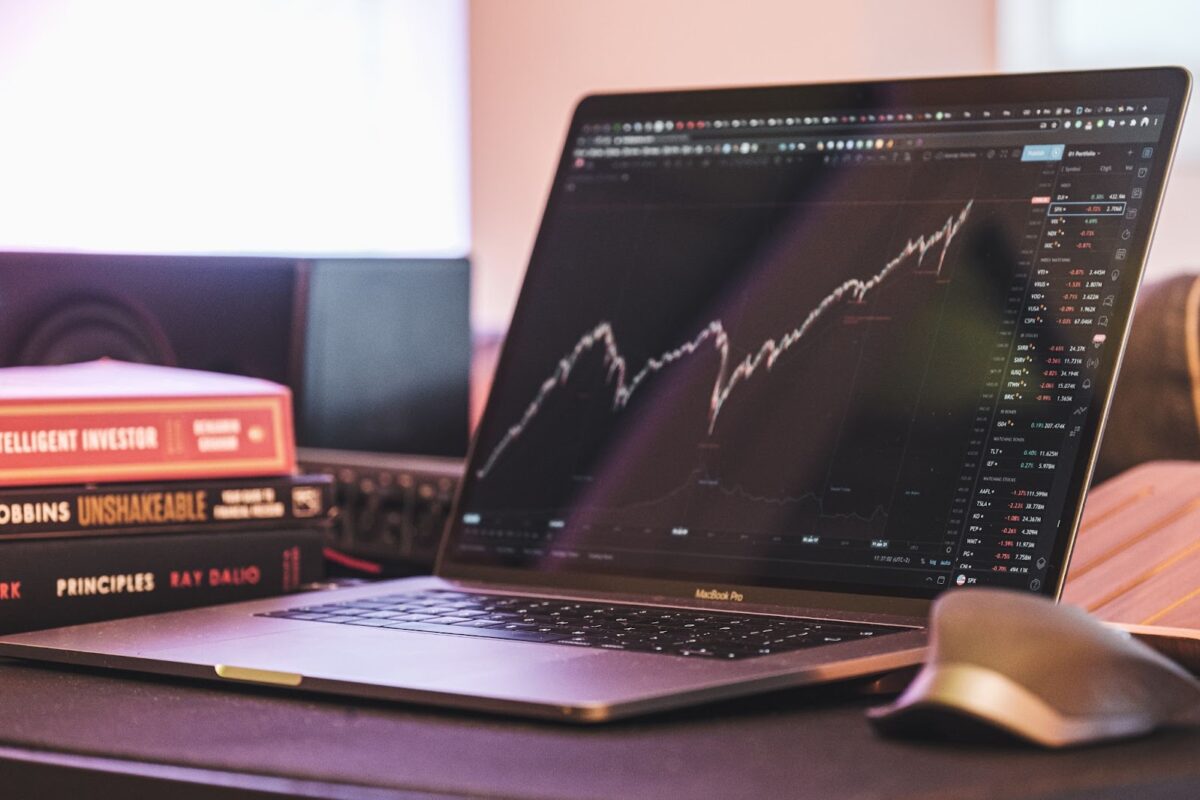 laptop in table with real estate market cycles chart on screen