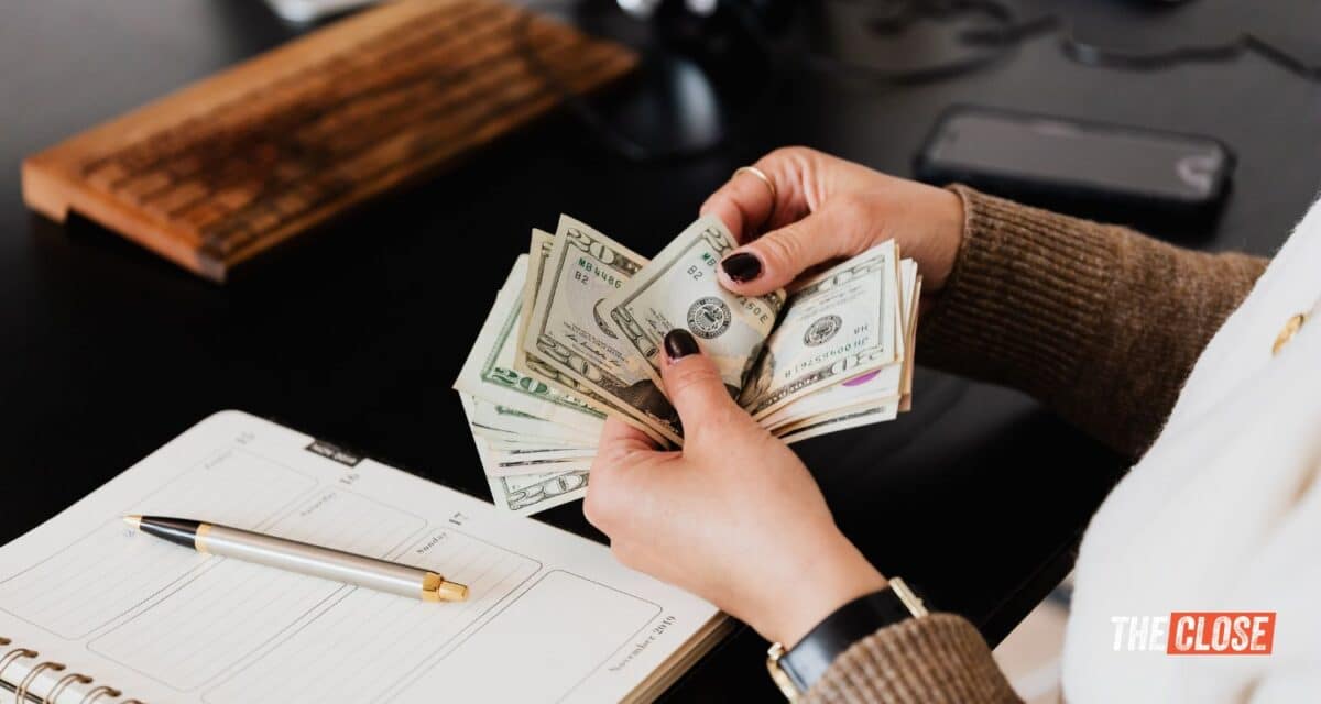 Real estate agent counting 20 dollar bills