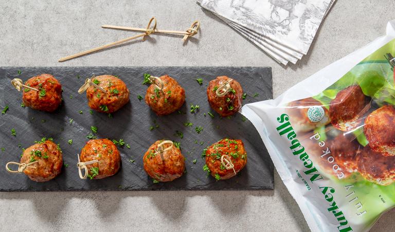 meatballs from Trader Joes lined up nicely on a plate, ready for passing around at the next open house.