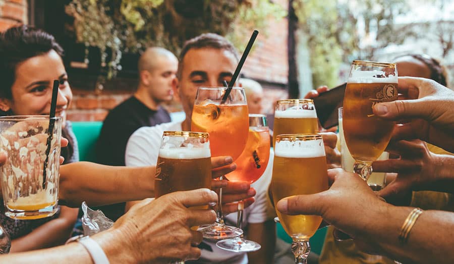 People cheering their beverages at a table.