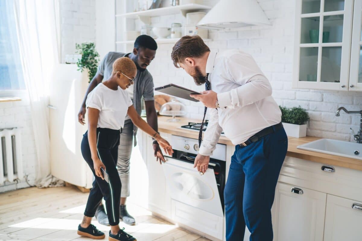 Real estate agent showing kitchen to a couple