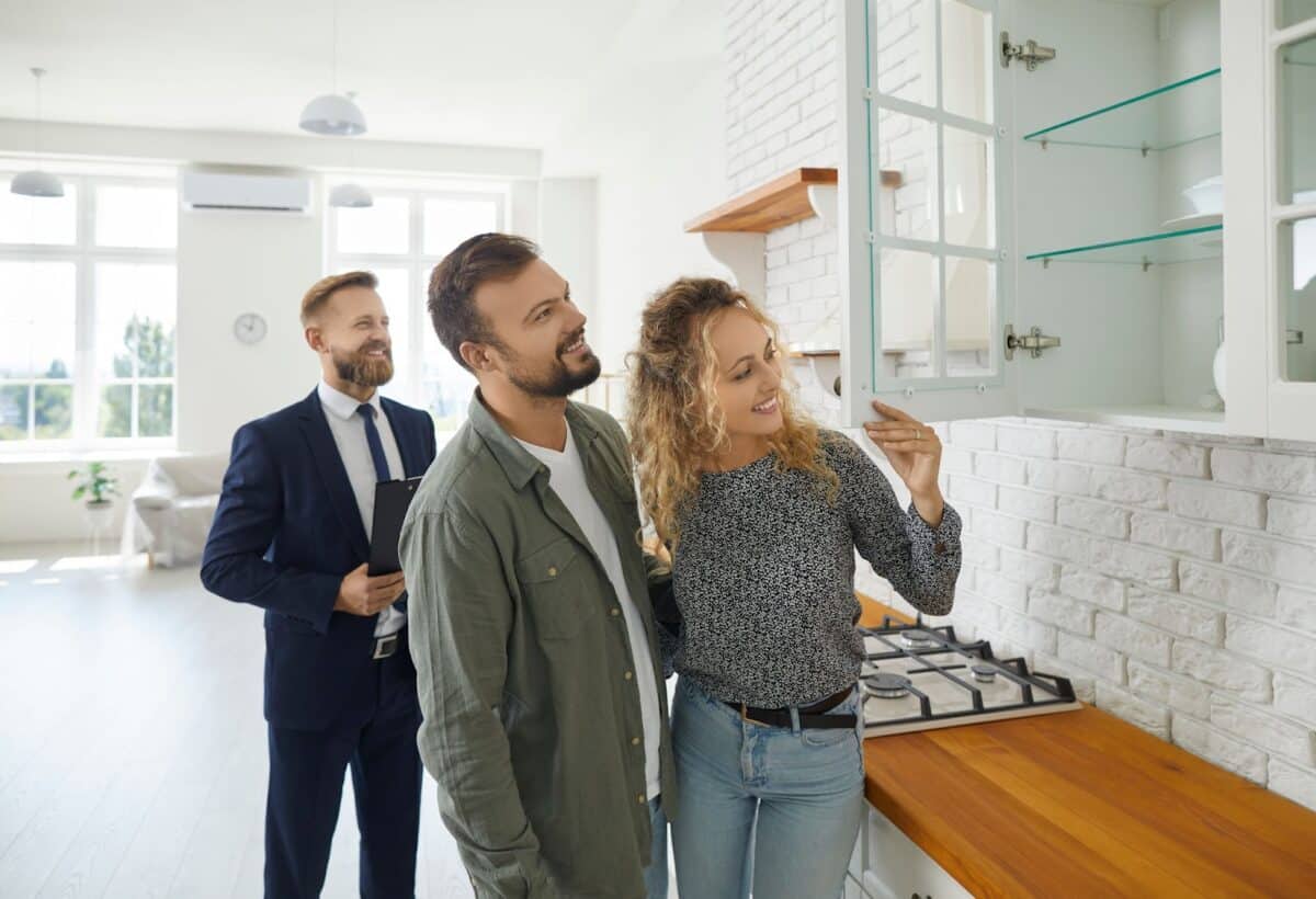 Future tenants meeting real estate agent and looking around a home