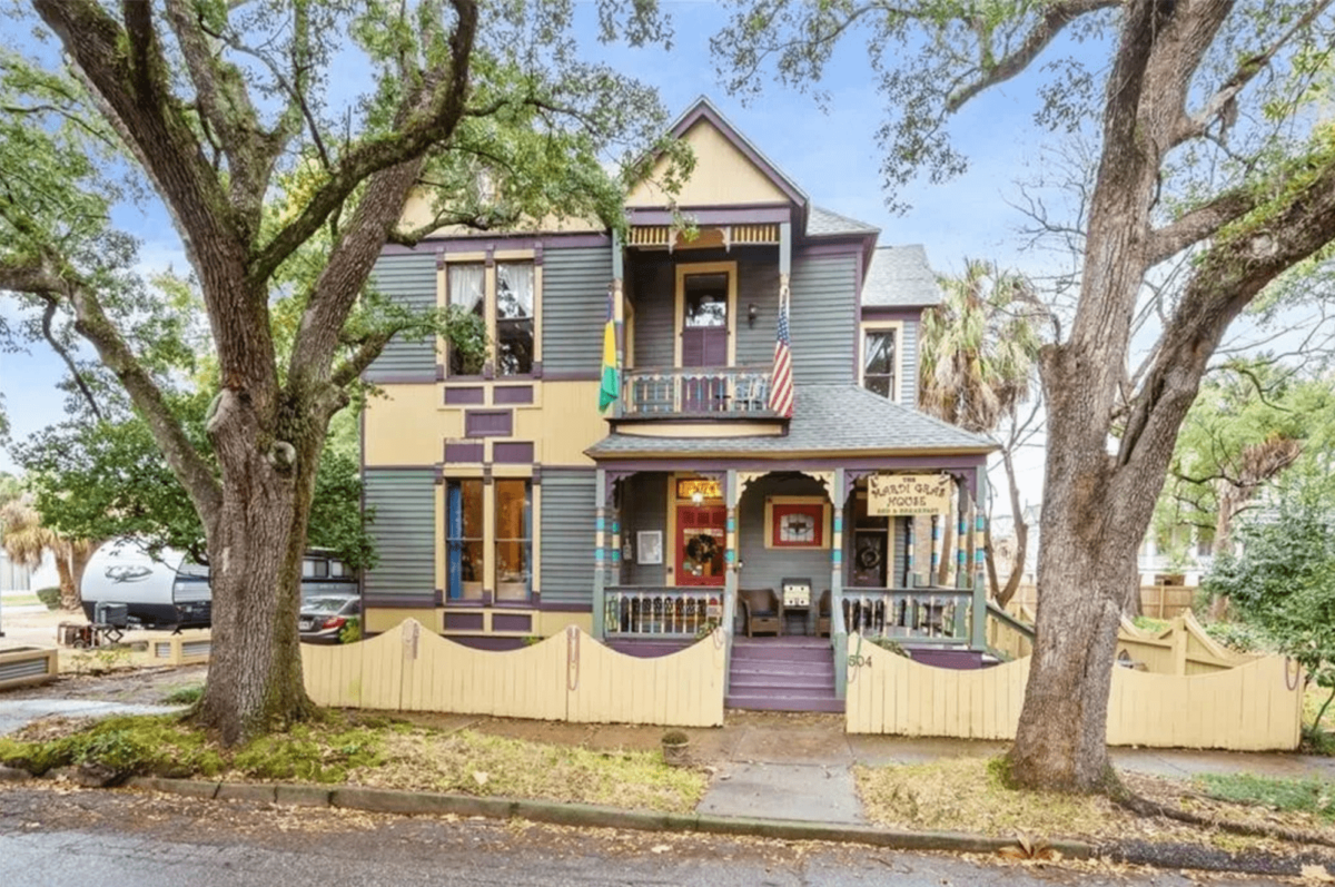 A two-story house with trees next to it